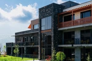 an apartment building with a balcony and patio at Dili Town Resort and Spa in Dilijan