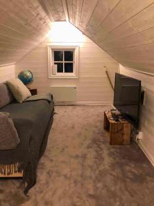a living room with a bed and a tv in a tent at Country Cottage By Natural Pond In Söderköping in Gusum