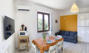 a living room with a table and a blue couch at Birsa's Rooms in Cagliari