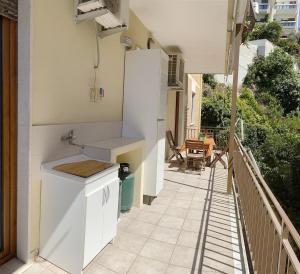 a white kitchen with a counter and a balcony at Birsa's Rooms in Cagliari