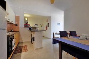 een keuken en eetkamer met een tafel en een aanrecht bij Noa's in SantʼAnna Arresi