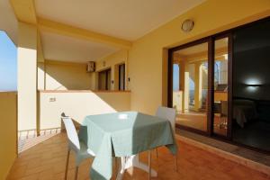 een eetkamer met een blauwe tafel en stoelen bij Noa's in SantʼAnna Arresi +3 foto's