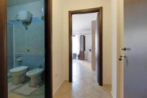 een badkamer met een toilet en een deur naar een gang bij Noa's in SantʼAnna Arresi