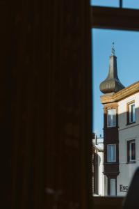 a window view of a building with a bell tower at Boutique Hotel Engadinerhof - A Home for Generations in Pontresina