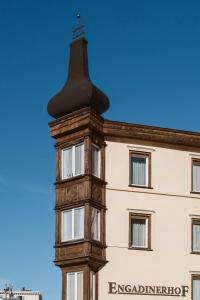 a building with a cross on top of a building at Boutique Hotel Engadinerhof - A Home for Generations in Pontresina +111 photos