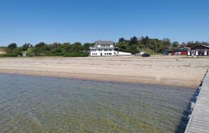 a white house on the shore of a beach at 2 Bedroom Stunning Home In Øster Assels in Øster Assels