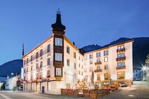 a building with a tower on the side of a street at Boutique Hotel Engadinerhof - A Home for Generations in Pontresina