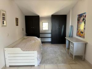 a bedroom with a white bed and a desk at Maison village provençal in Éguilles