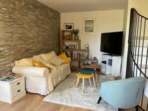 a living room with a couch and a tv at Maison village provençal in Éguilles +10 photos