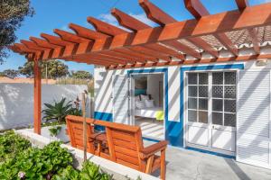Una pérgola sobre un patio con dos sillas. en Canto do Mar, en Mosteiros