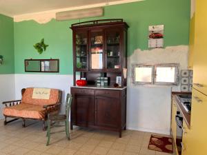 a kitchen with a cabinet and a chair and a window at Villino Relax in Portopalo