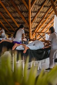 a group of people sitting on beds in a room at MAKAI BEACH HOSTEL in Punta de Piedra