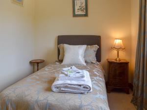 une chambre avec un lit avec des serviettes dessus dans l'établissement Russet Cottage, à Moreton-in-Marsh 3 autres photos