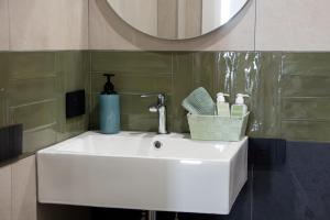 ein weißes Waschbecken in einem Badezimmer mit einem Spiegel in der Unterkunft vesuvius115 in Neapel + 127 Fotos