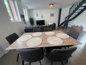 a dining room with a wooden table and chairs at La Parisienne - 80m2 in Vierzon