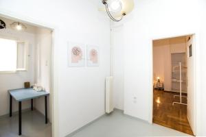 um quarto com uma mesa e uma parede branca em Athens Central Jacuzzi Retreat em Atenas
