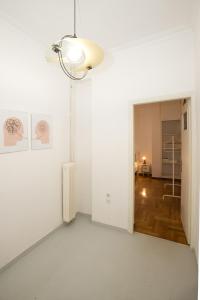 um quarto branco com uma ventoinha de tecto e um corredor em Athens Central Jacuzzi Retreat em Atenas