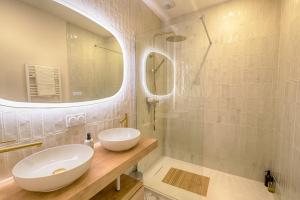 ein Badezimmer mit einem weißen Waschbecken und einem Spiegel in der Unterkunft Escapade - Ciné privé, balnéo et jardin in Saint-Ambroix