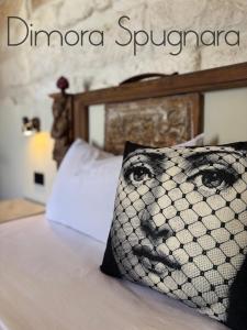 a bed with a pillow with a face on it at Dimora Spugnara in Lampedusa