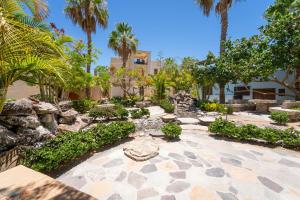 un jardín con palmeras y rocas y un edificio en Casa del Amor, en Loreto