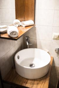 a white sink in a bathroom with towels on a shelf at Φιλυρέα Apartments - Room 4 in Zagora