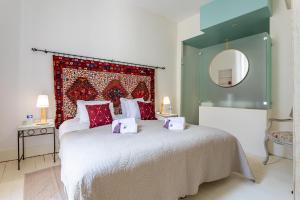 a bedroom with a large bed with a red headboard at Appartement "La Marquise" centre de Grignan in Grignan +13 photos