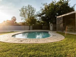 a swimming pool in a yard with a patio at Alte Welkom Guesthouse in Klerksdorp
