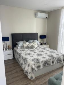 a bedroom with a bed with a black and white comforter at Toes in the sand in São Roque