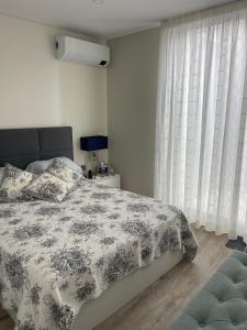 a bedroom with a bed and a window with curtains at Toes in the sand in São Roque