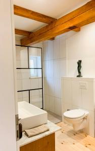 a bathroom with a white tub and a toilet at Cozy Holiday Home In The Mecklenburg Lake District in Hohen Demzin
