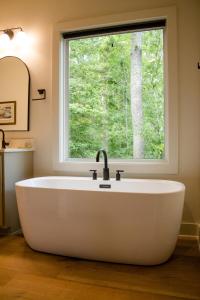una bañera en un baño con ventana en Tipi Cabin Lake D'Arbonne, en Farmerville