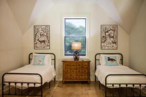 Dos camas individuales en una habitación con ventana. en Tipi Cabin Lake D'Arbonne, en Farmerville