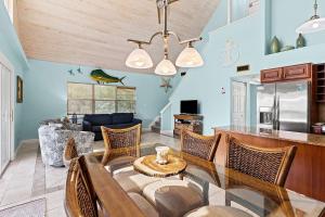 a dining room and living room with a table and chairs at Kon Tiki - Waterfront Pool Home Near Sombrero Beach, 30' Dock, Tiki Hut in Marathon