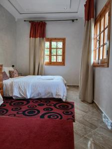a bedroom with a bed and a red rug at villa ourika complette in Sbiti +22 photos