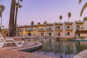 a resort with a swimming pool and a building with palm trees at Estero Beach Hotel & Resort in Ensenada +53 photos