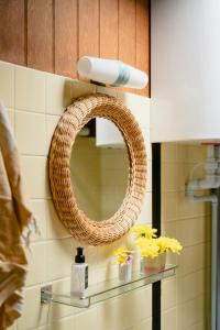 La salle de bains est pourvue d'un miroir et d'une étagère avec des fleurs. dans l'établissement 60S Cabin With Vintage Finds And Wild Surroundings, à Tjørneholm