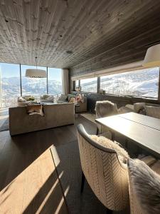 a living room with a couch and a table and chairs at Unique Cabin With Spa And Ski In-Ski Out in Hemsedal