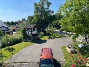 Un coche rojo aparcado en una entrada con un mirador. en Ferienwohnung am Bienenhaus, en Salem