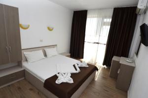 a hotel room with a bed with towels on it at Vila Bliss in Costinesti +22 photos