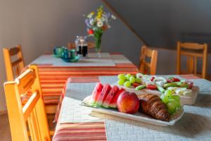 a plate of fruit on a table with a plate of food at Penzion Na Vyhlídce in Lukov