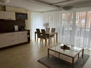 a living room with a table and chairs and a kitchen at Vila Nova Pervalka in Pervalka