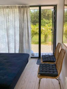 Un dormitorio con una cama y una silla y una ventana. en Modern Holiday Home By Limfjord, en Øster Assels