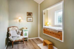 Zimmer mit einem Spiegel, einem Stuhl und einem Bett in der Unterkunft Family House With Sauna Near Ålbæk in Ålbæk