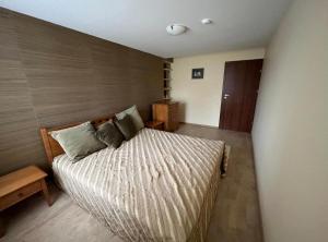 a bedroom with a large bed with a wooden wall at Vila Nova Pervalka in Pervalka
