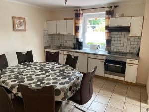 a kitchen with a table and a table and chairs at Haus Dorfidyll in Rodershausen