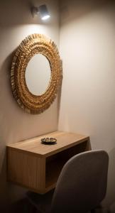 a mirror on a wall next to a table with a chair at Gemini in Laganas