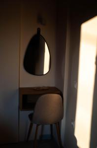 a desk with a chair and a mirror on a wall at Gemini in Laganas