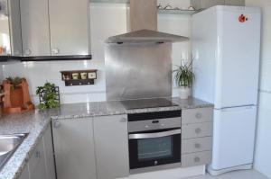 a kitchen with a stove and a refrigerator at Villa Jordana Urbapol One Step To The Beach in San Pol de Mar