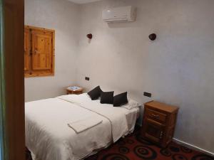 a bedroom with two beds with white sheets and a wooden cabinet at villa ourika complette in Sbiti +28 photos