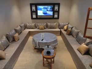 a living room with a couch and a tv at villa ourika complette in Sbiti